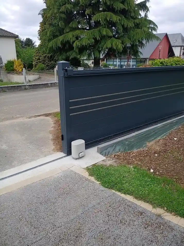Portail coulissant motorisé en aluminium anthracite avec son rail