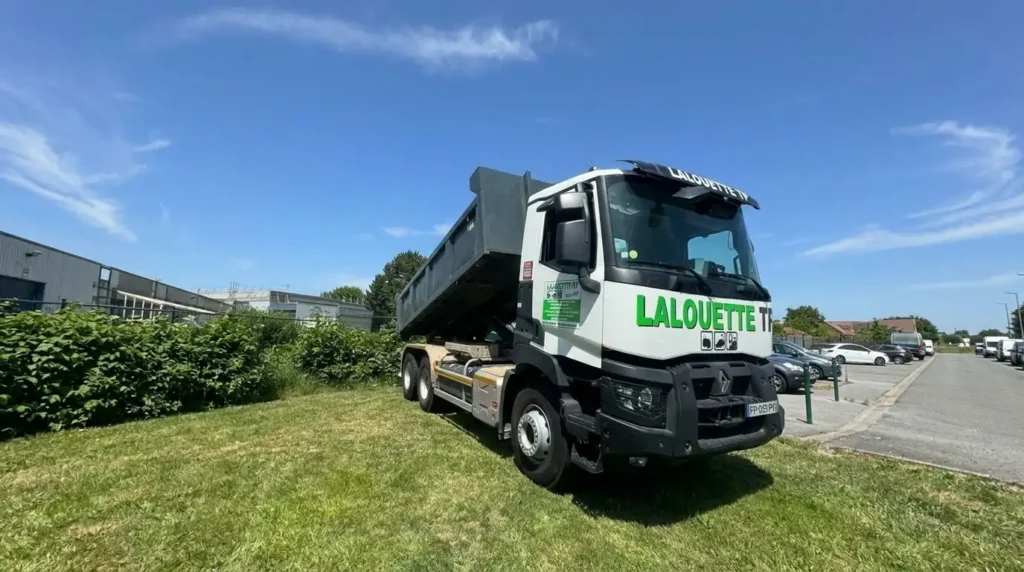 Camion benne de terrassement floqué Lalouette TP garé sur un terrain